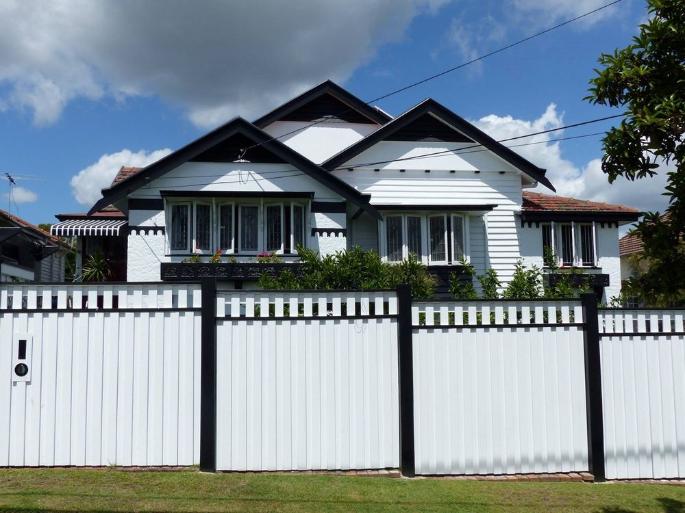 Ashgrove house from the street behind a white fence with black posts