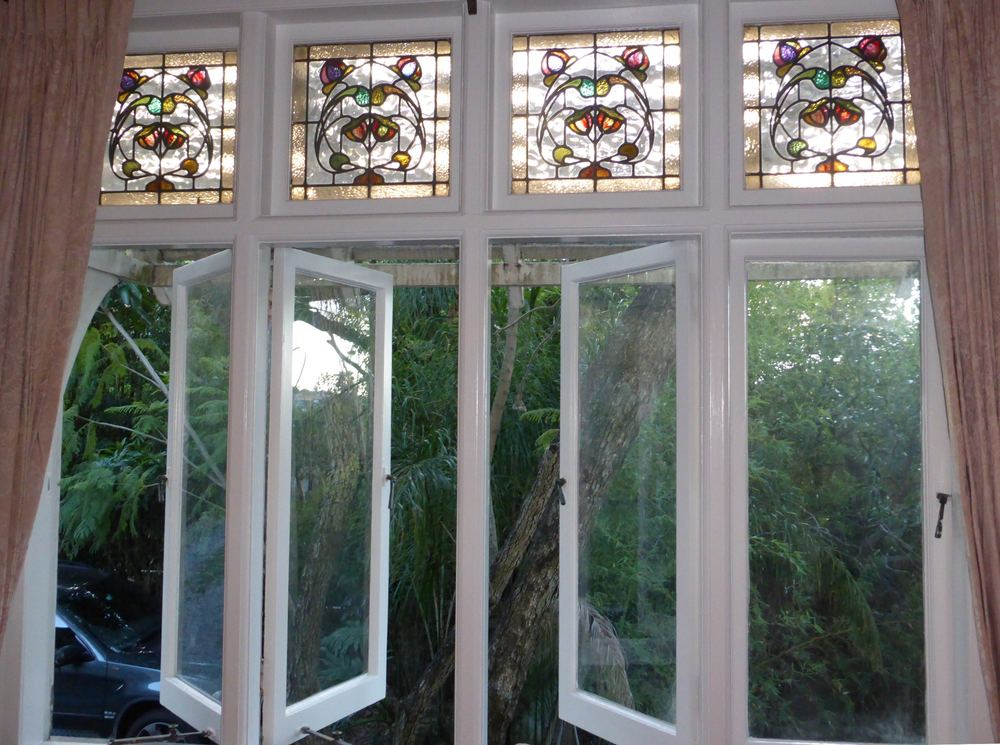 Clayfield casement windows with stained-glass toplights, frames painted white
