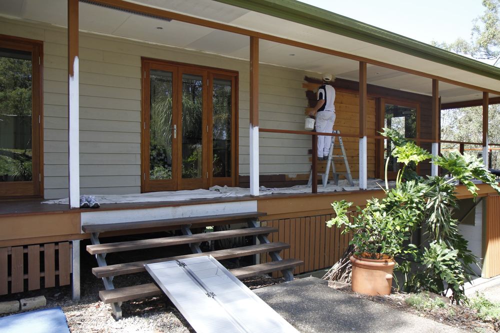 Michael on a ladder painting the exterior of the Clear Mountain house
