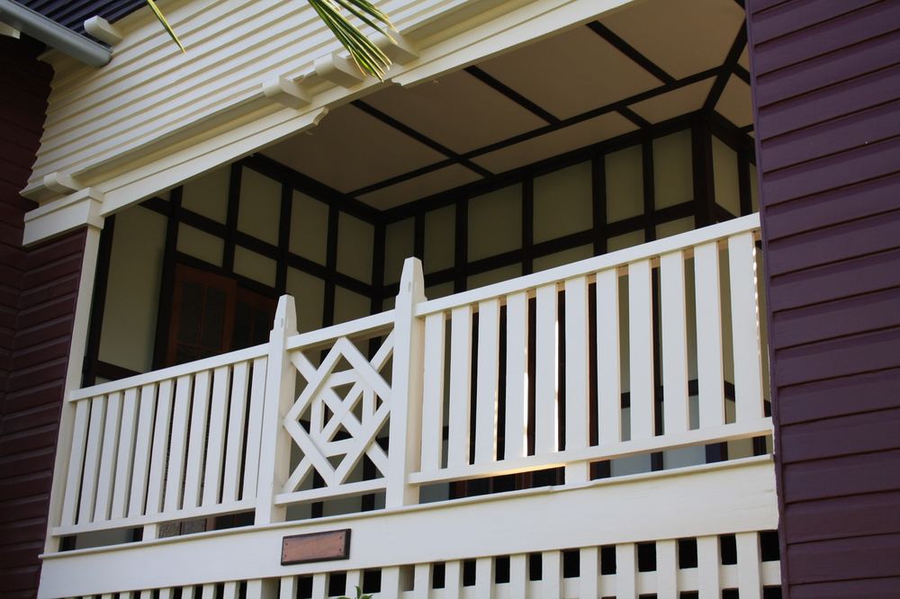 Enoggera balcony with white railings and a crossed timber panel